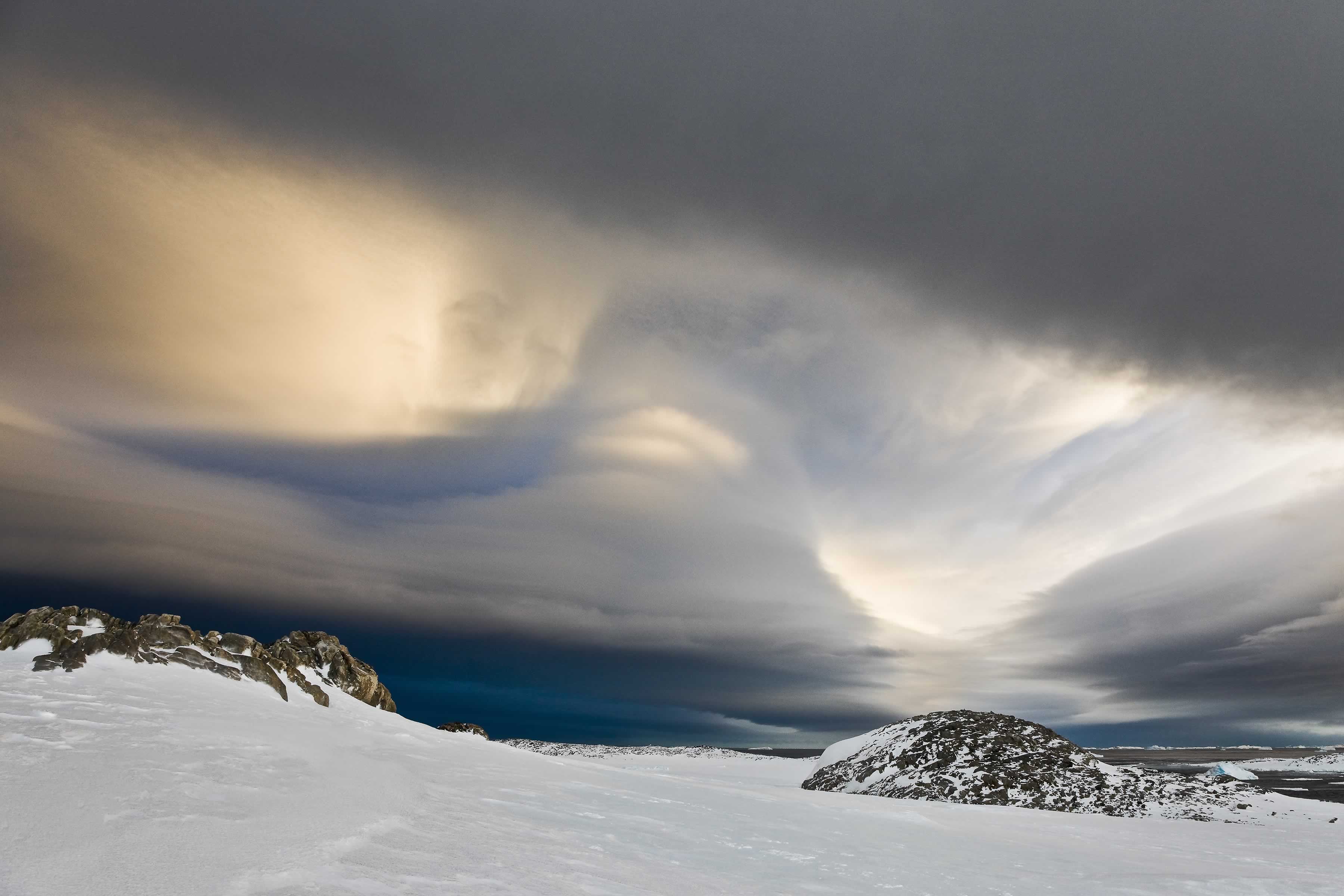 Grey dark cloud formation moving in under bright wind sculptured clouds. Photo: Ian Phillips.